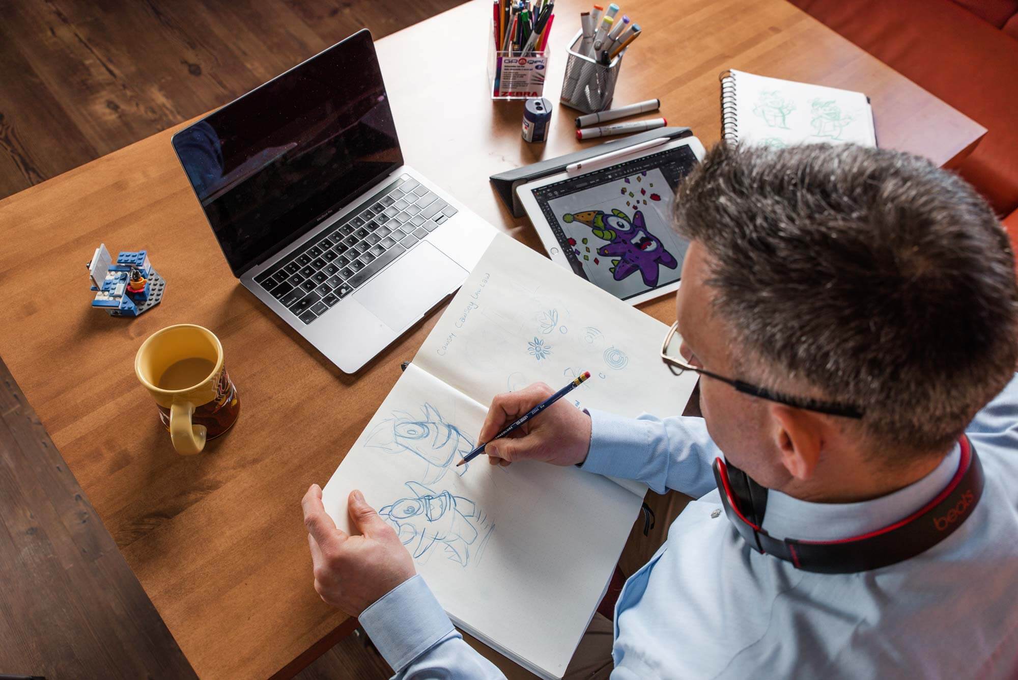 Brian-22 Graphic Designer, Brian Olstad sketching at a design workstation